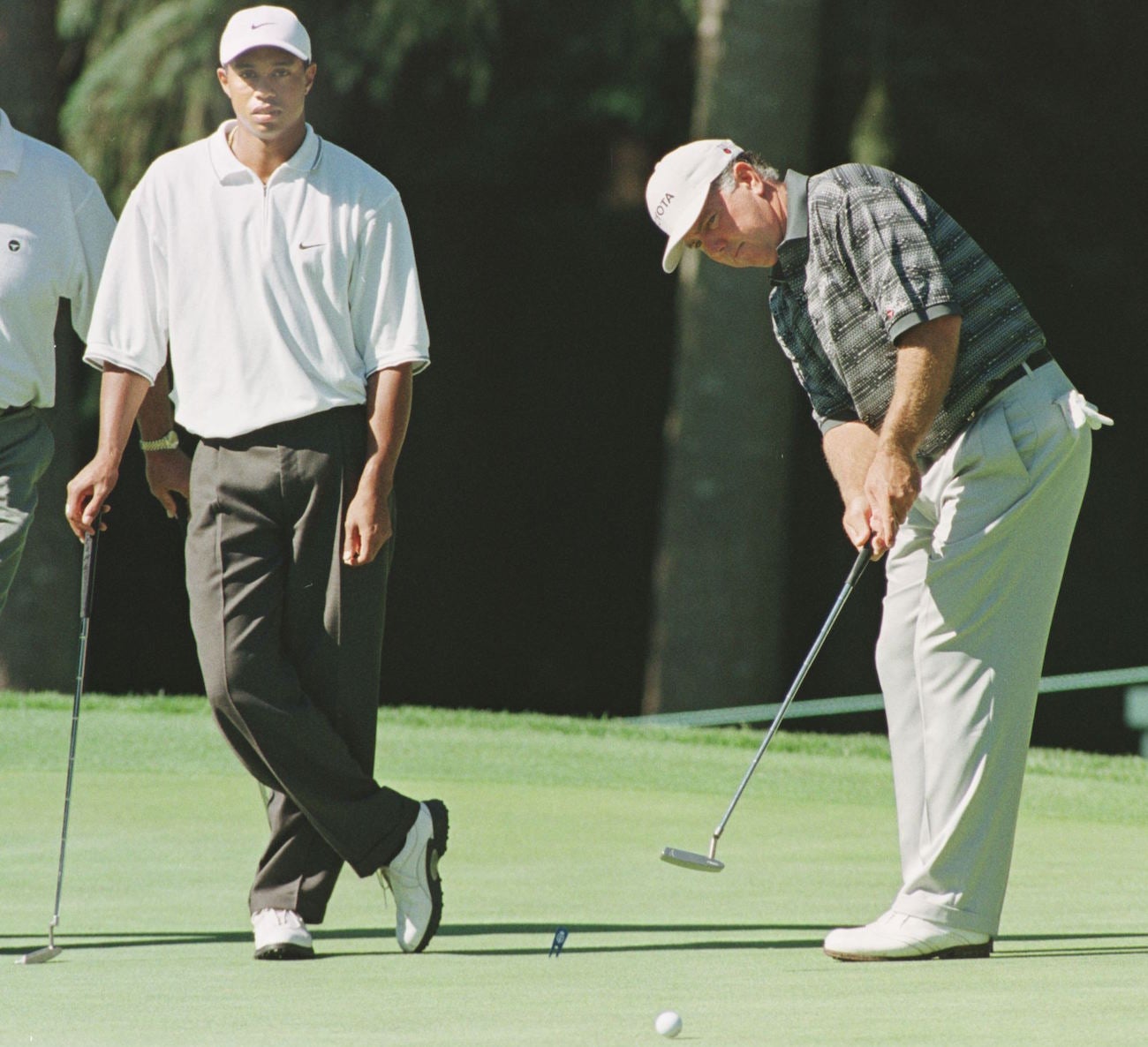 Tiger Woods watches Mark O'Meara putt ahead of the 1998 PGA Championship.