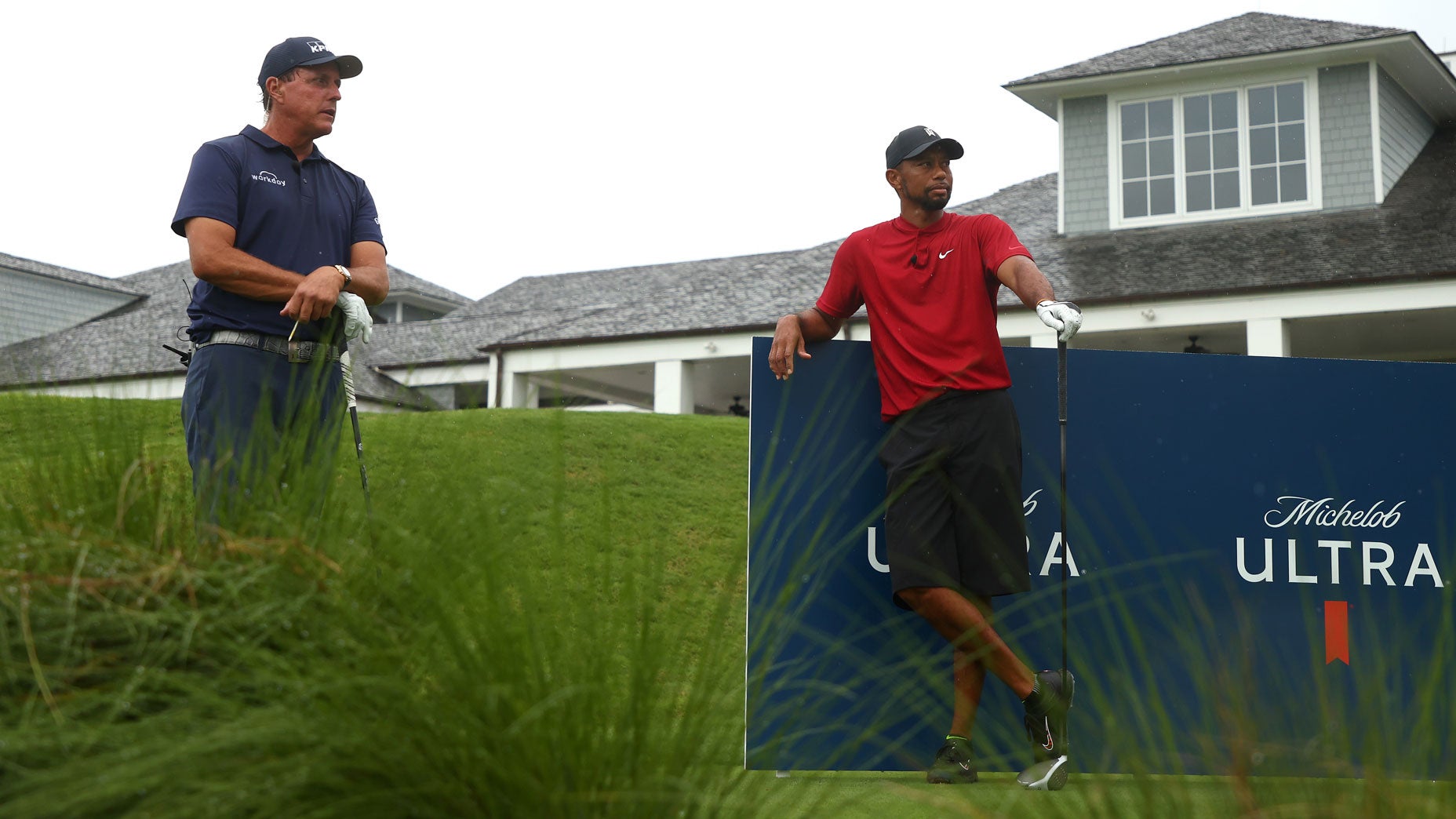 Phil Mickelson and Tiger Woods wait to tee off on the 10th hole at Medalist Golf Club.