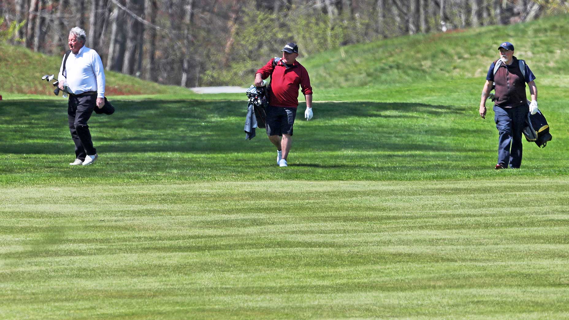 golfers carrying golf bags