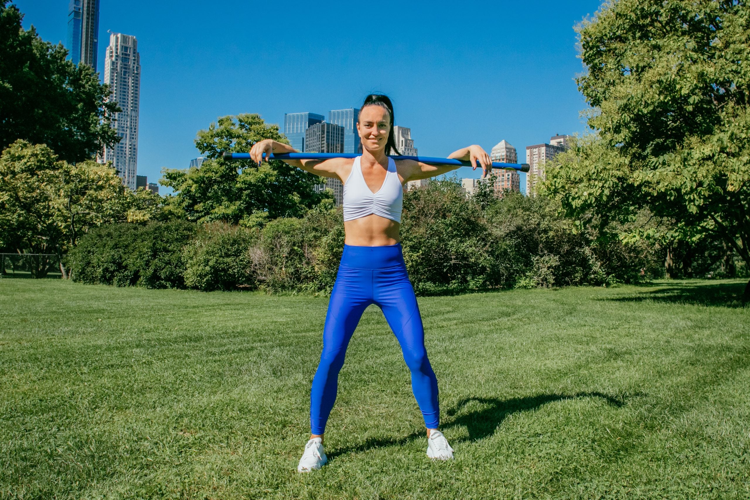 An instructor demonstrates a hamstring stretch.
