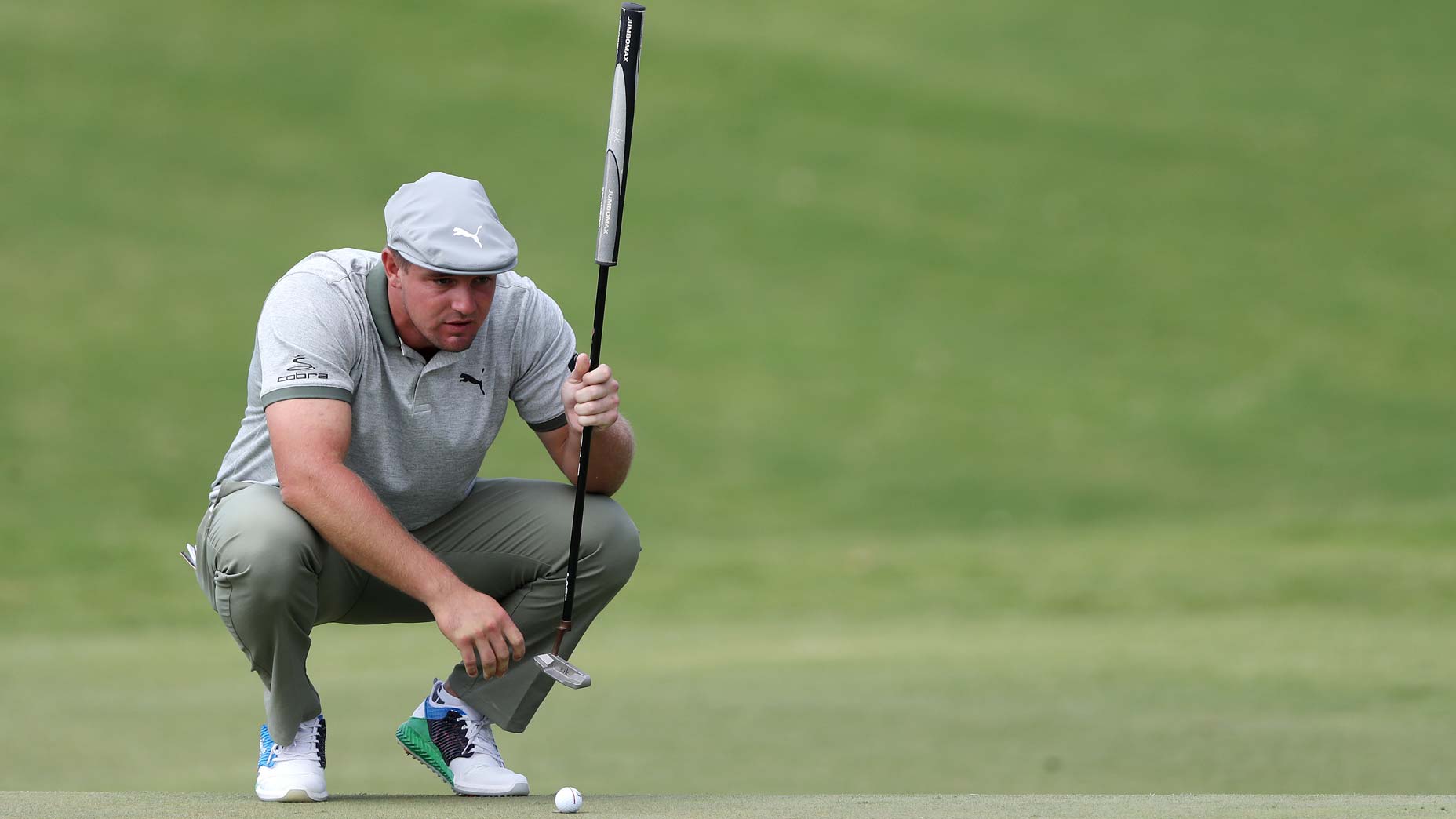 bryson dechambeau lines up putt