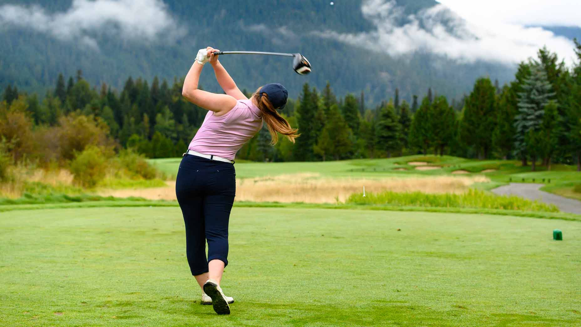 Female golfer teeing off