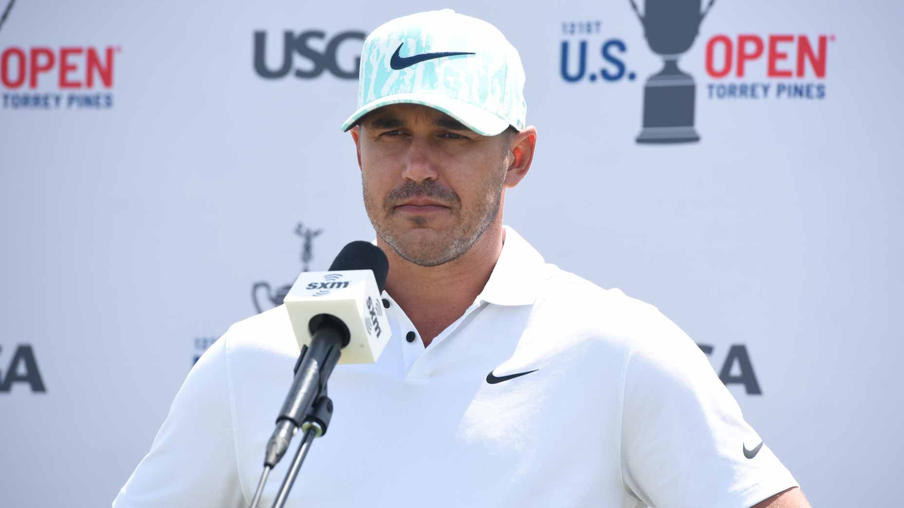 brooks Koepka stands at podium