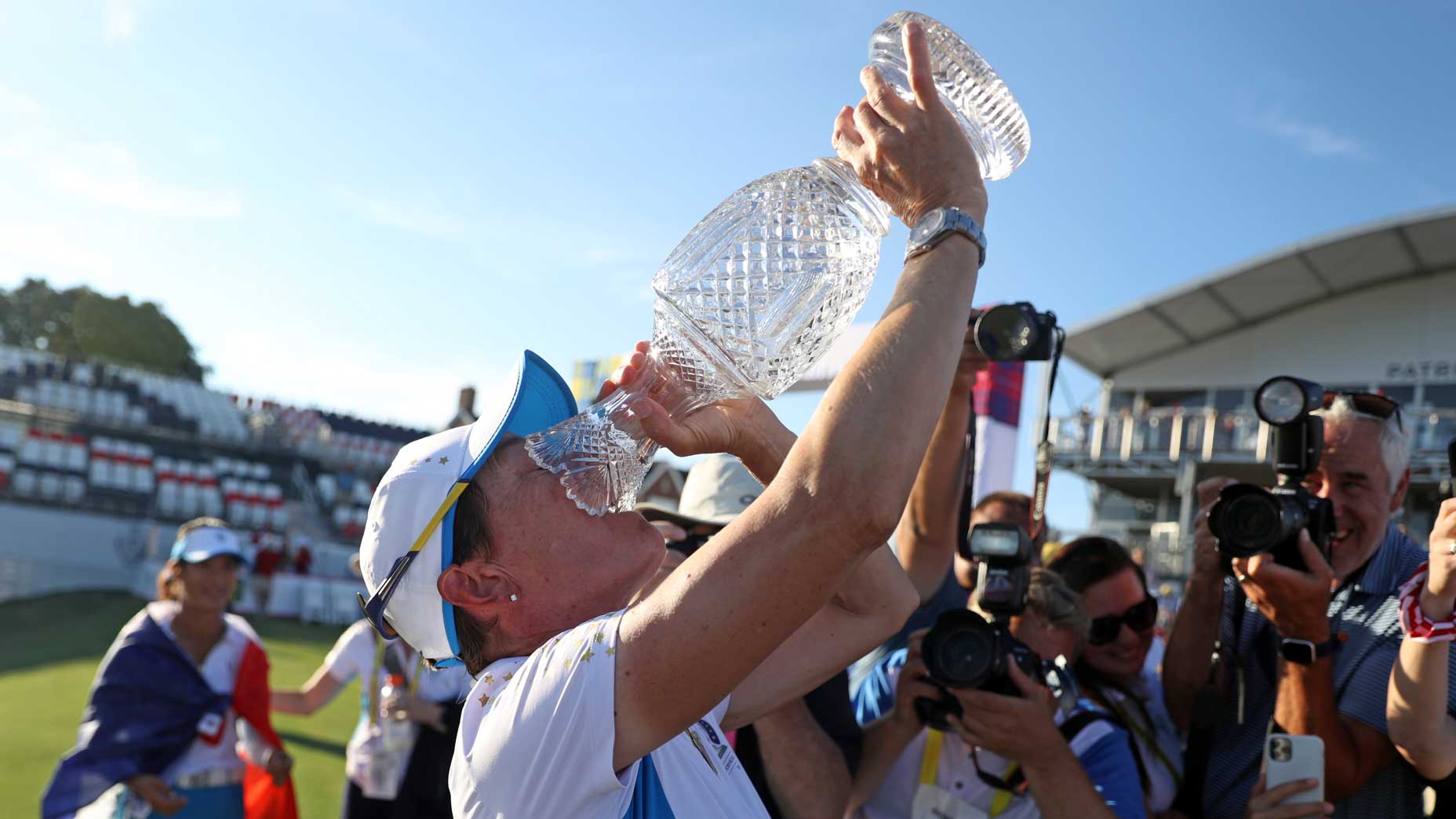 woman drinks from trophy