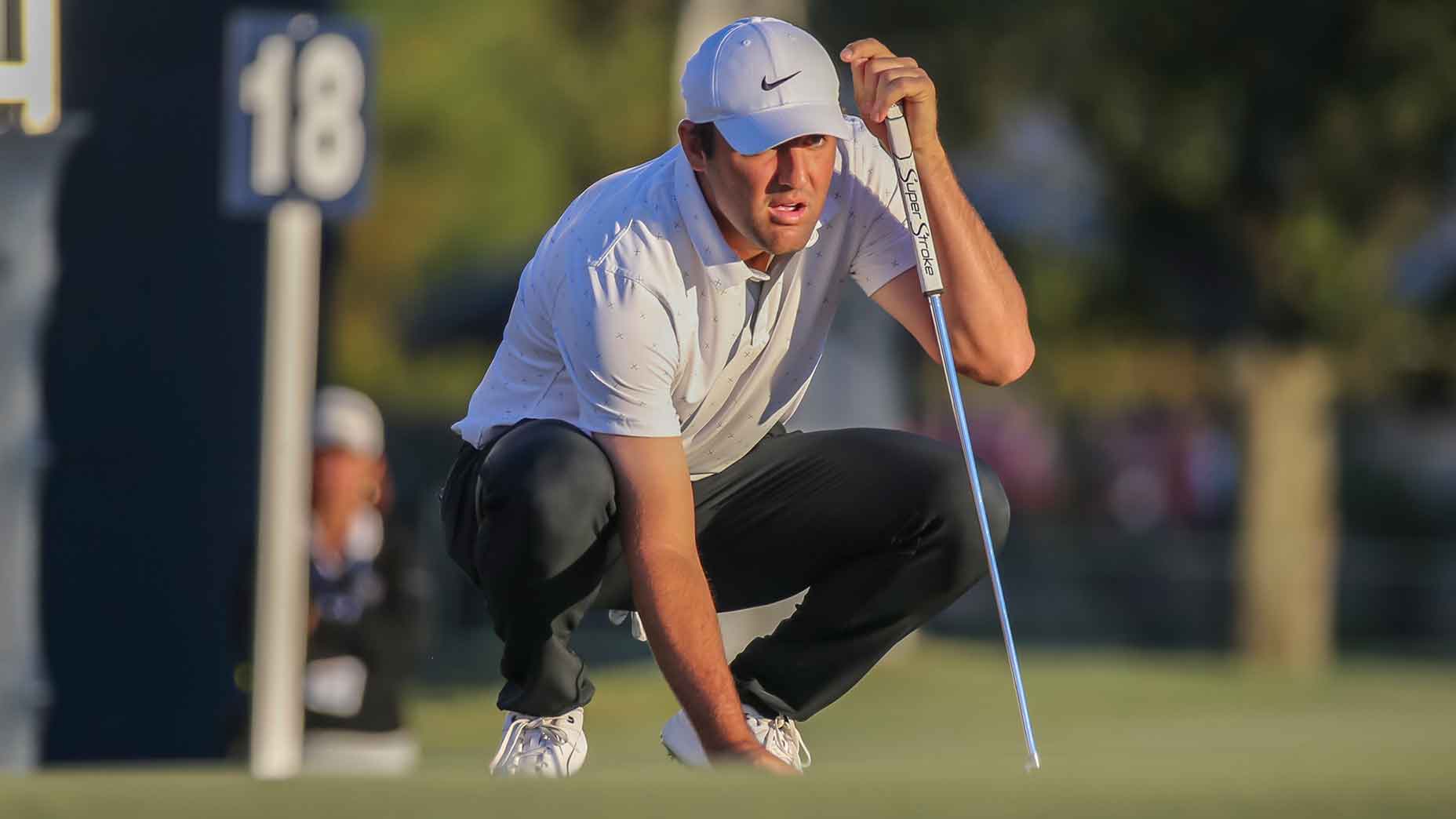 scottie scheffler lines up putt