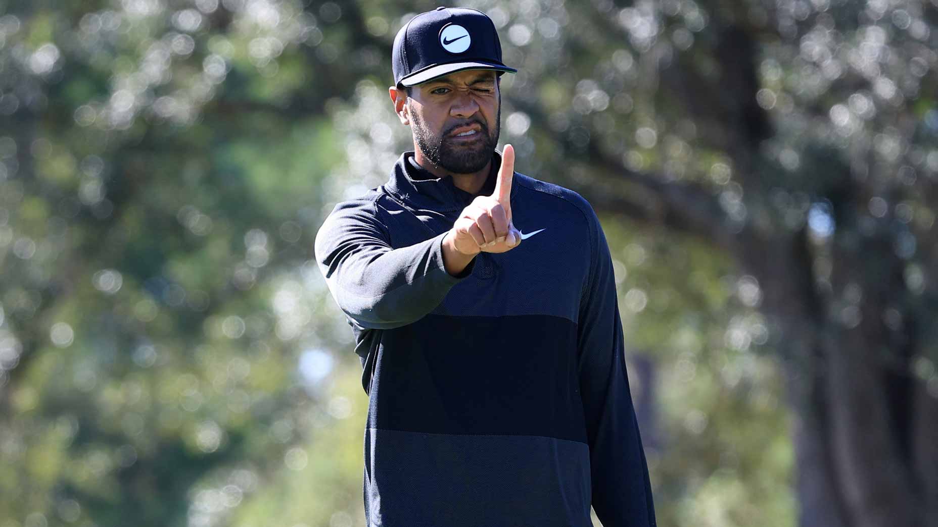 Tony Finau raises finger reading putt at 2022 Cadence Bank Houston Open