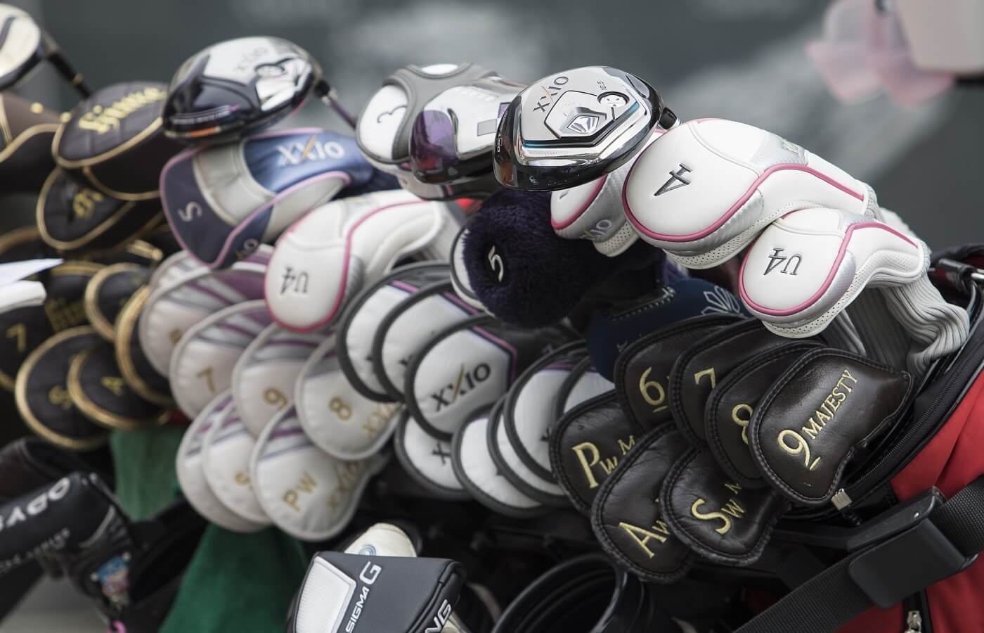 Many golf clubs with covers on them