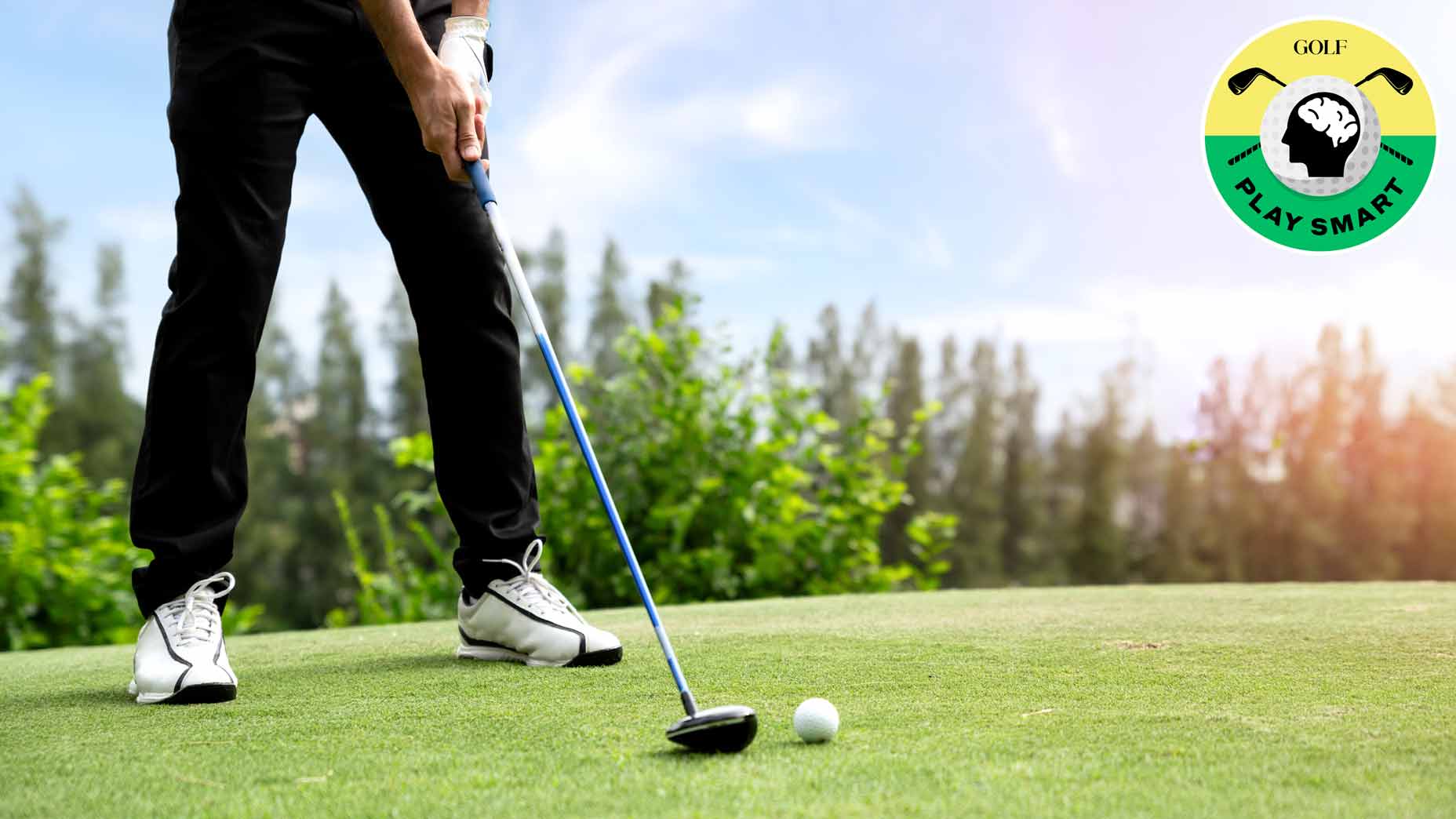 golfer stands on tee box with their club behind a ball on a tee