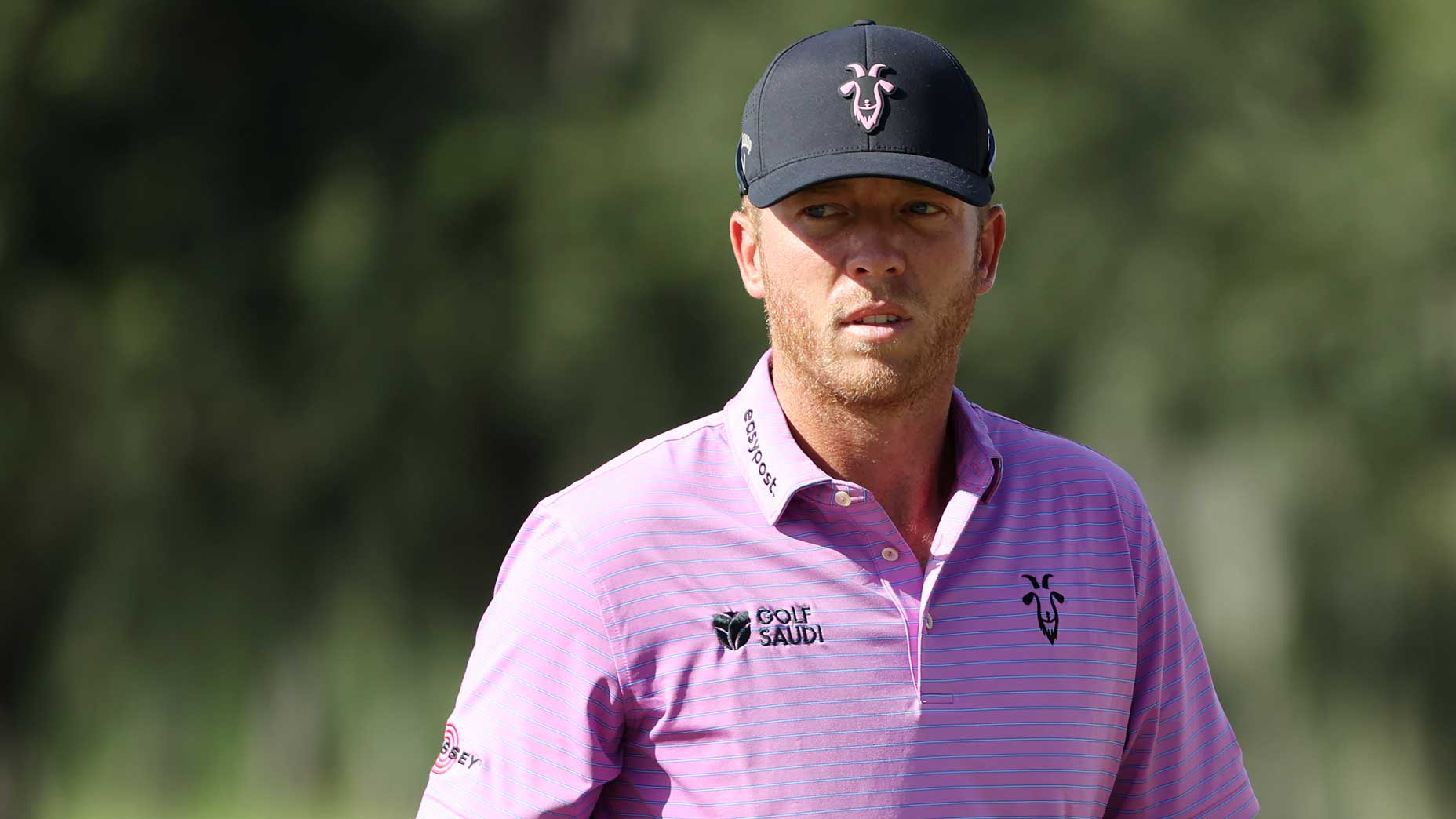 talor gooch looks on at a liv golf tournament