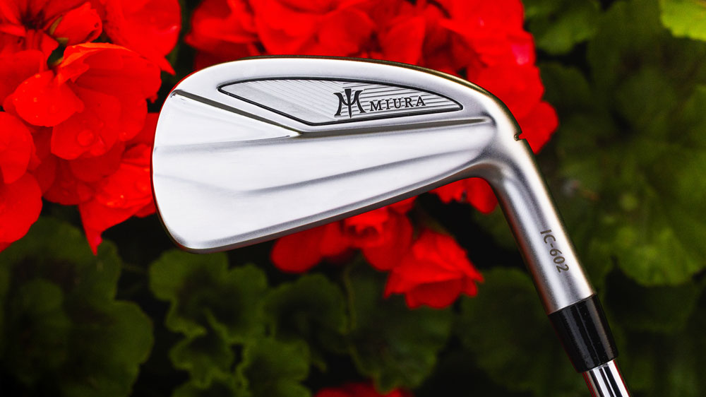 Miura IC-602 irons pictured with red flowers behind them