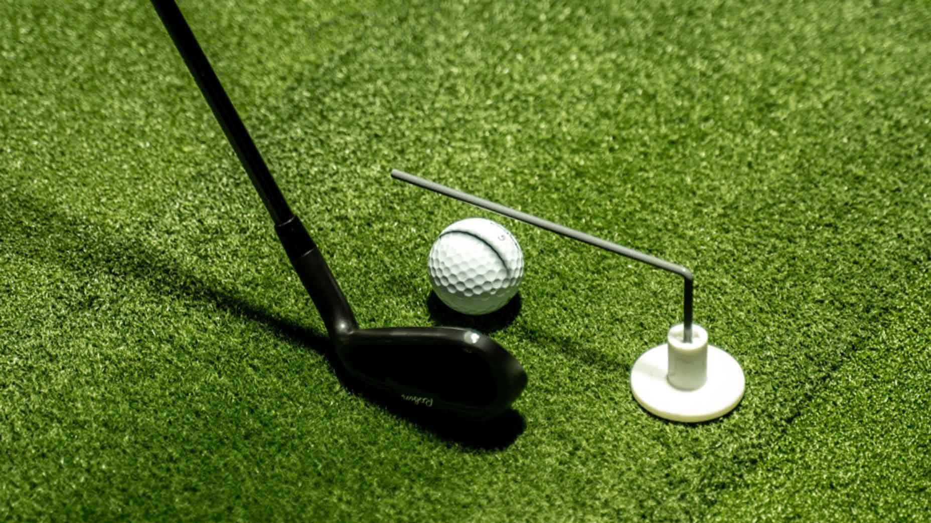 swingzy on the ground with golf ball and club next to it