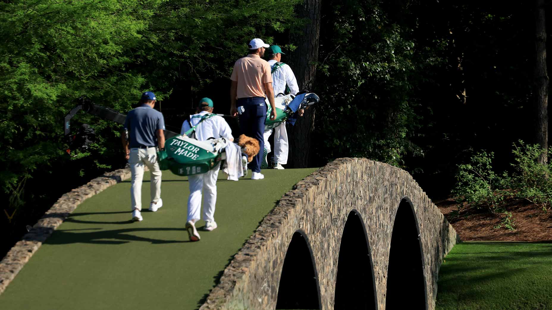 Scottie Scheffler walks across the Hogan bridge at the 2024 Masters.
