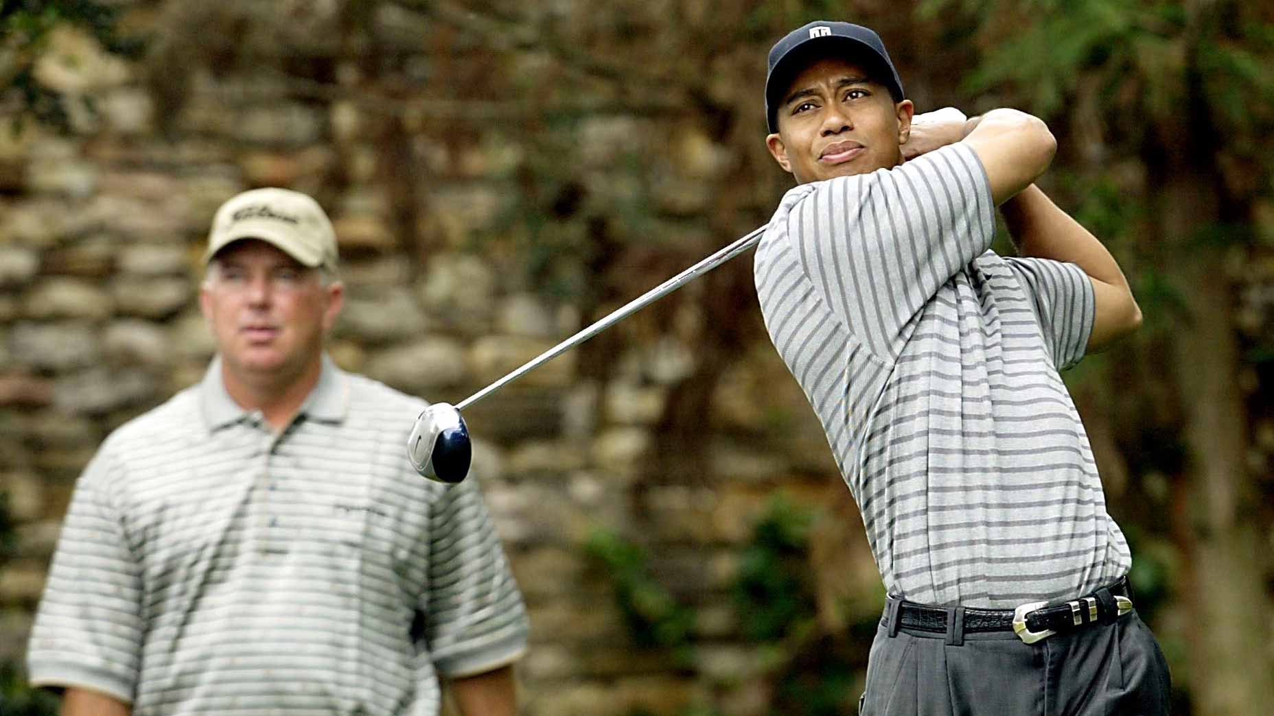 Tiger Woods hits a shot with Mark O'Meara watching at the Masters.
