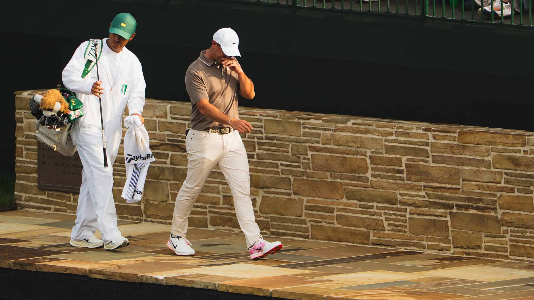 Rory McIlroy and caddie walk across Augusta National brdige during 2025 Masters.