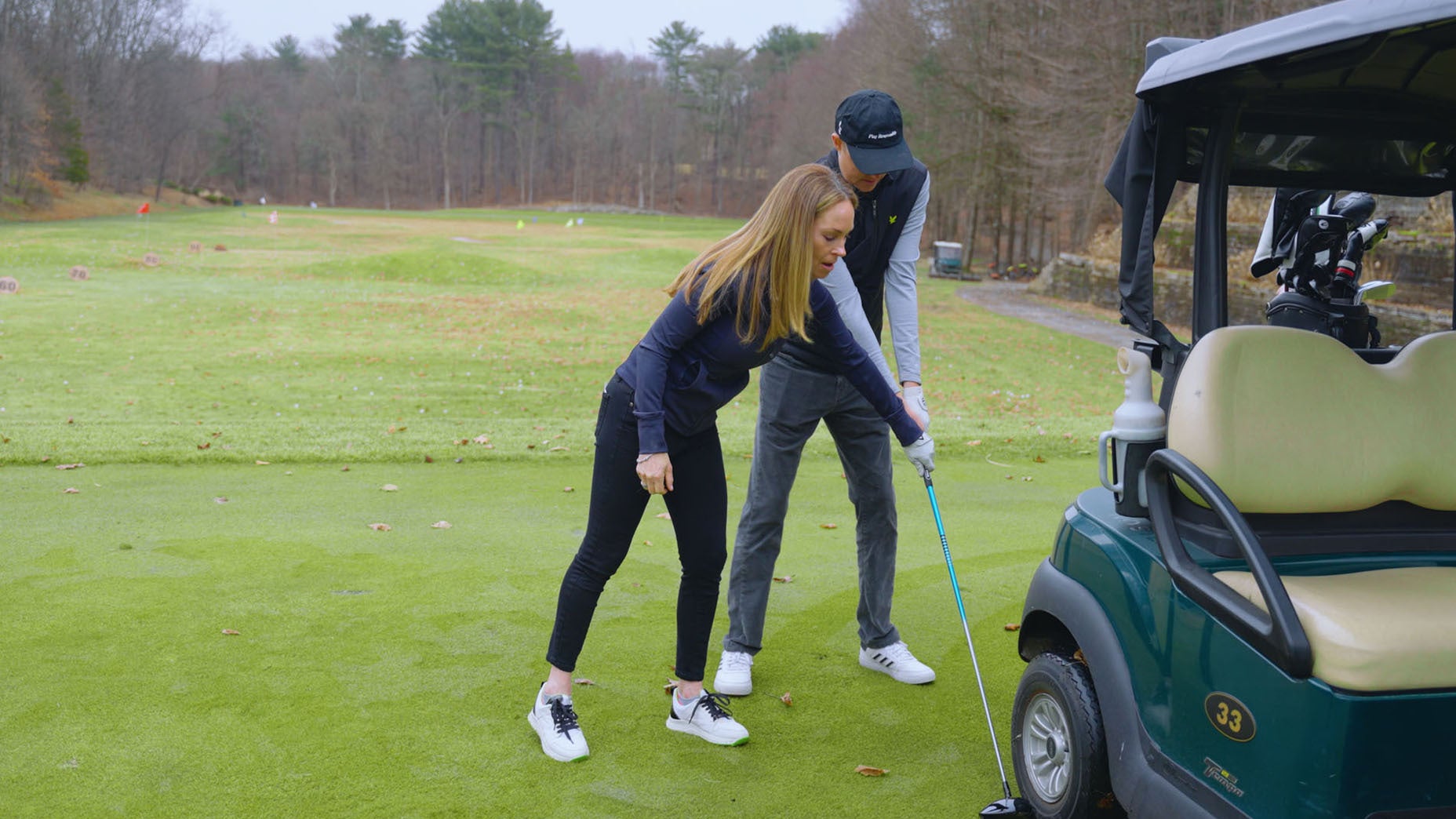 golf instructor shows student how to properly grip the golf club