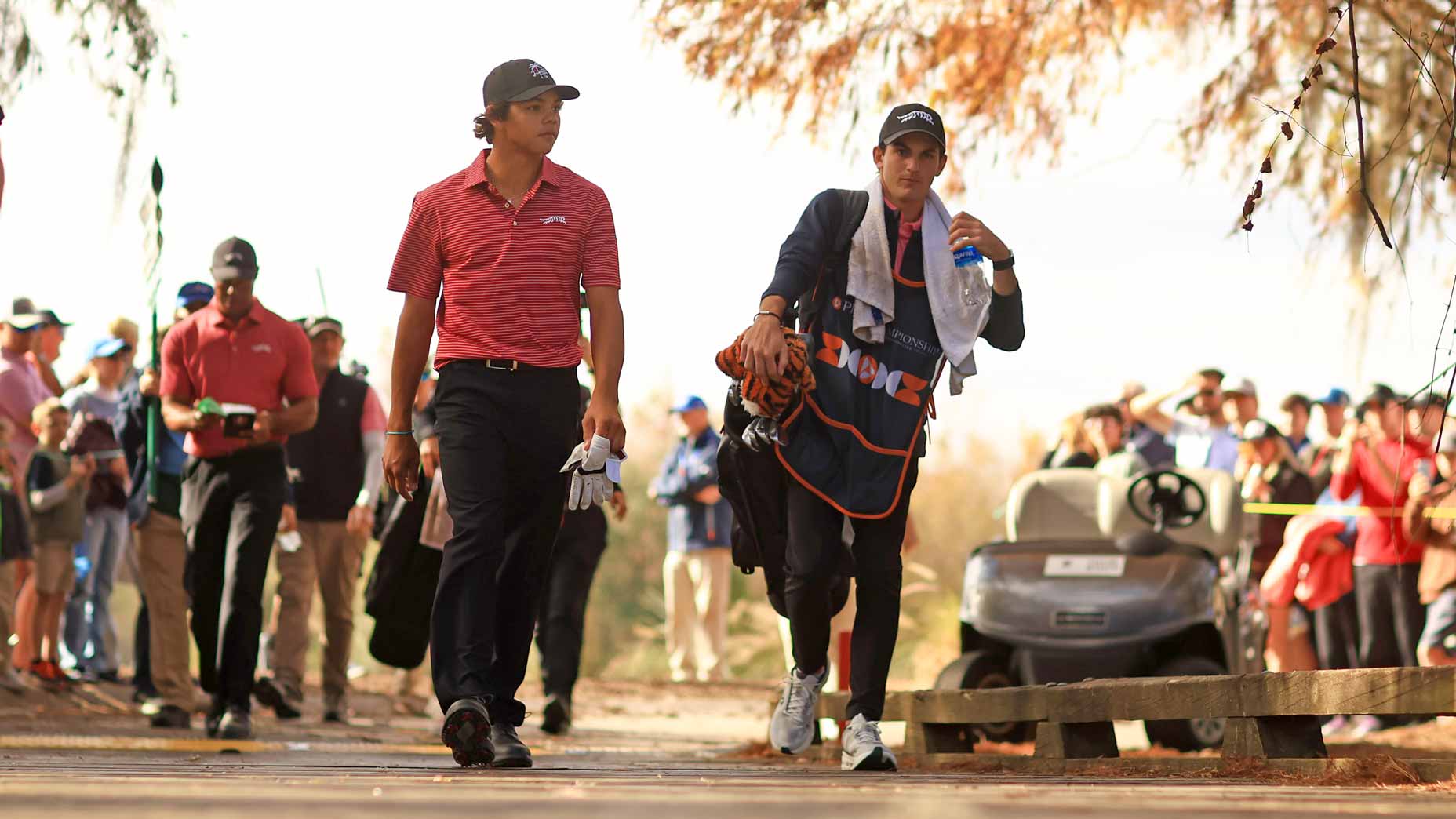 Charlie Woods and Tiger Woods walk course during the 2024 PNC Championship at Ritz-Carlton Golf Club.