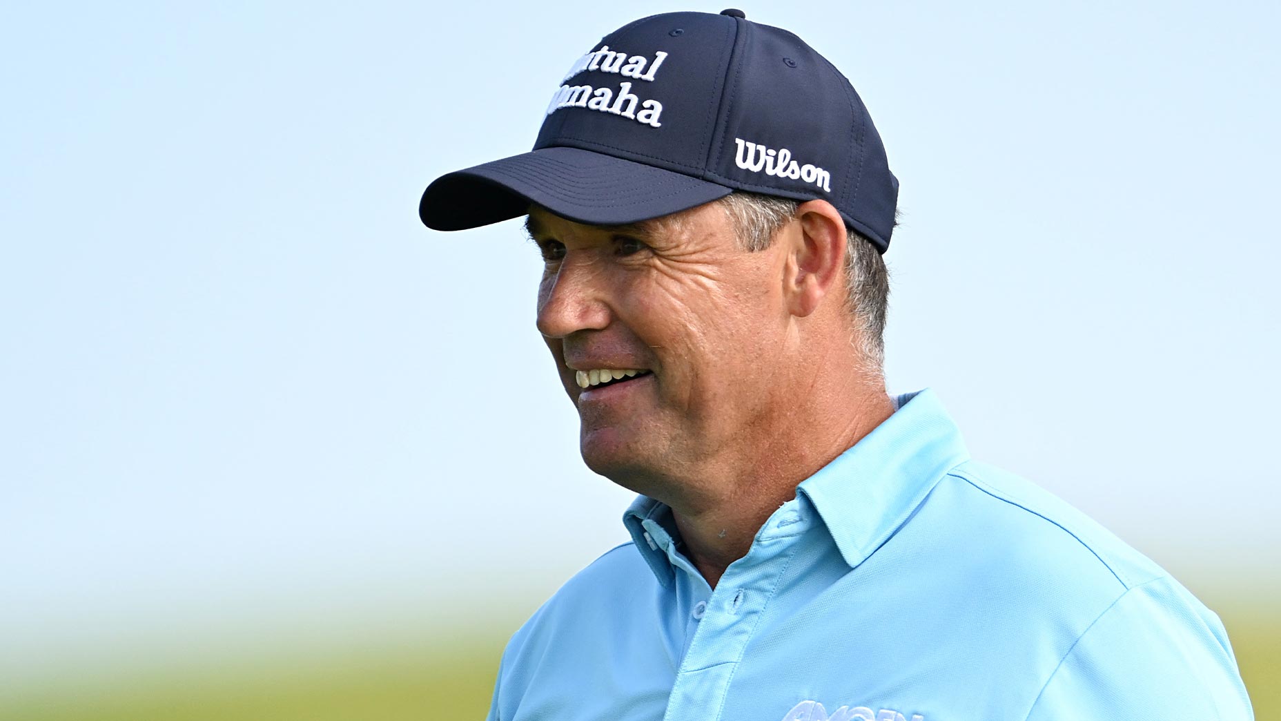 padraig harrington smiles at the open championship at royal portrush in blue shirt and blue hat