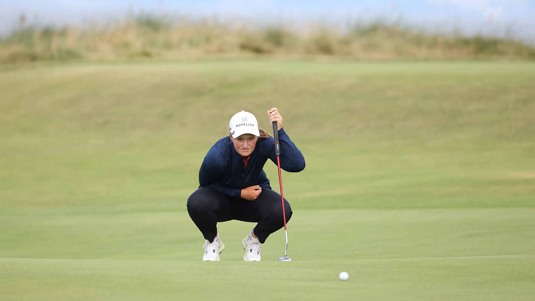 Lottie Woad lines up a putt using her signature red line.