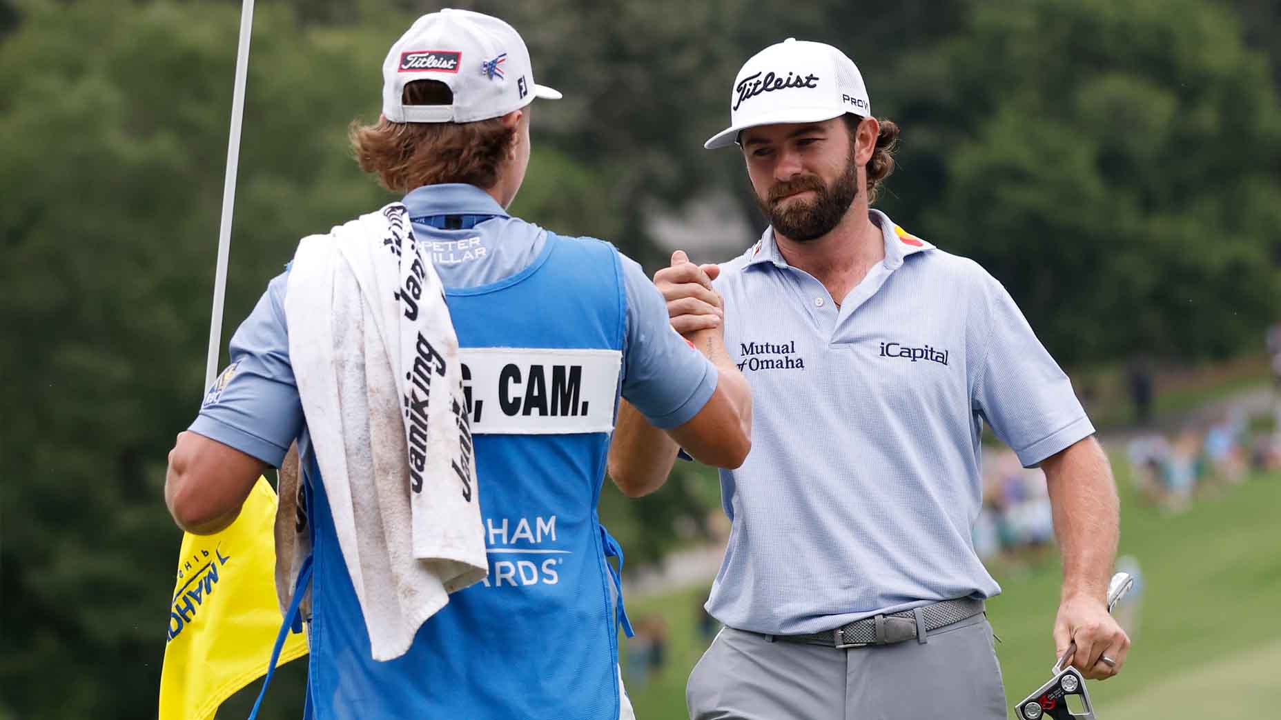 Cameron Young celebrates with his caddie after winning the Wyndham Championship