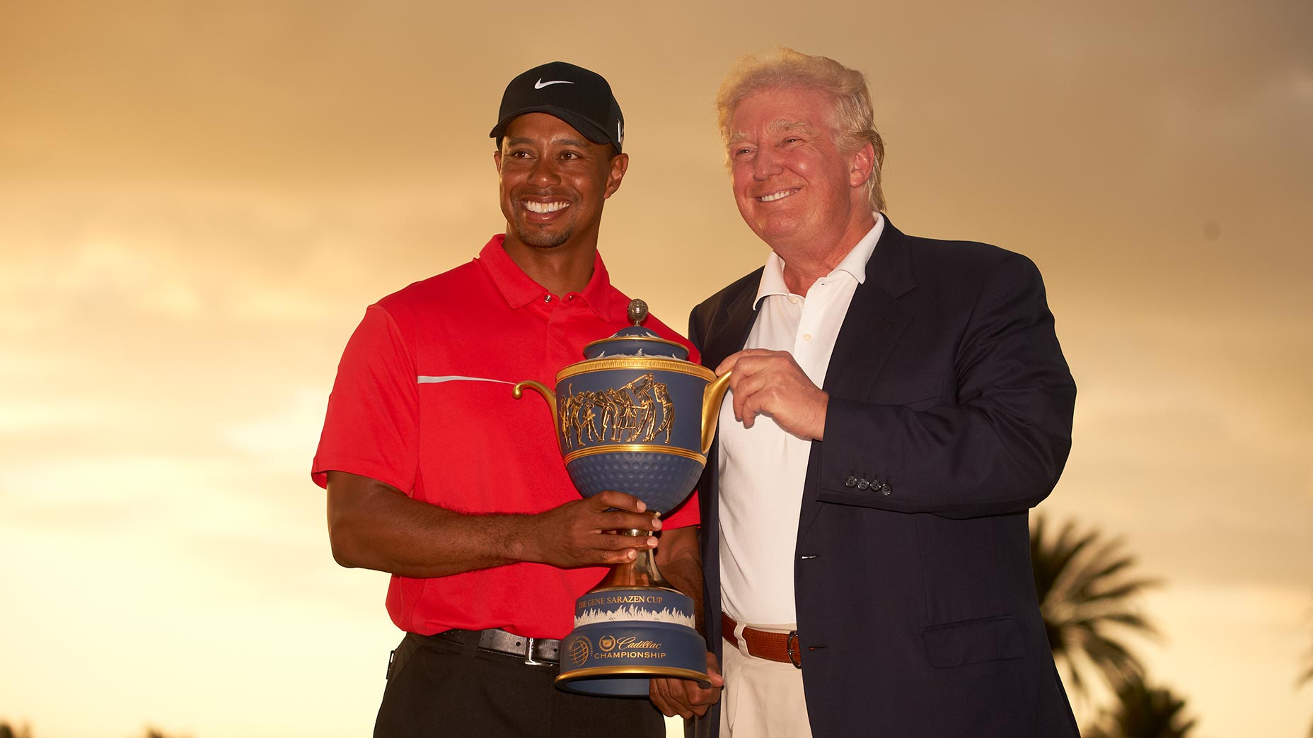 tiger woods and donald trump pose with the wgc-cadillac trophy at Trump Doral.