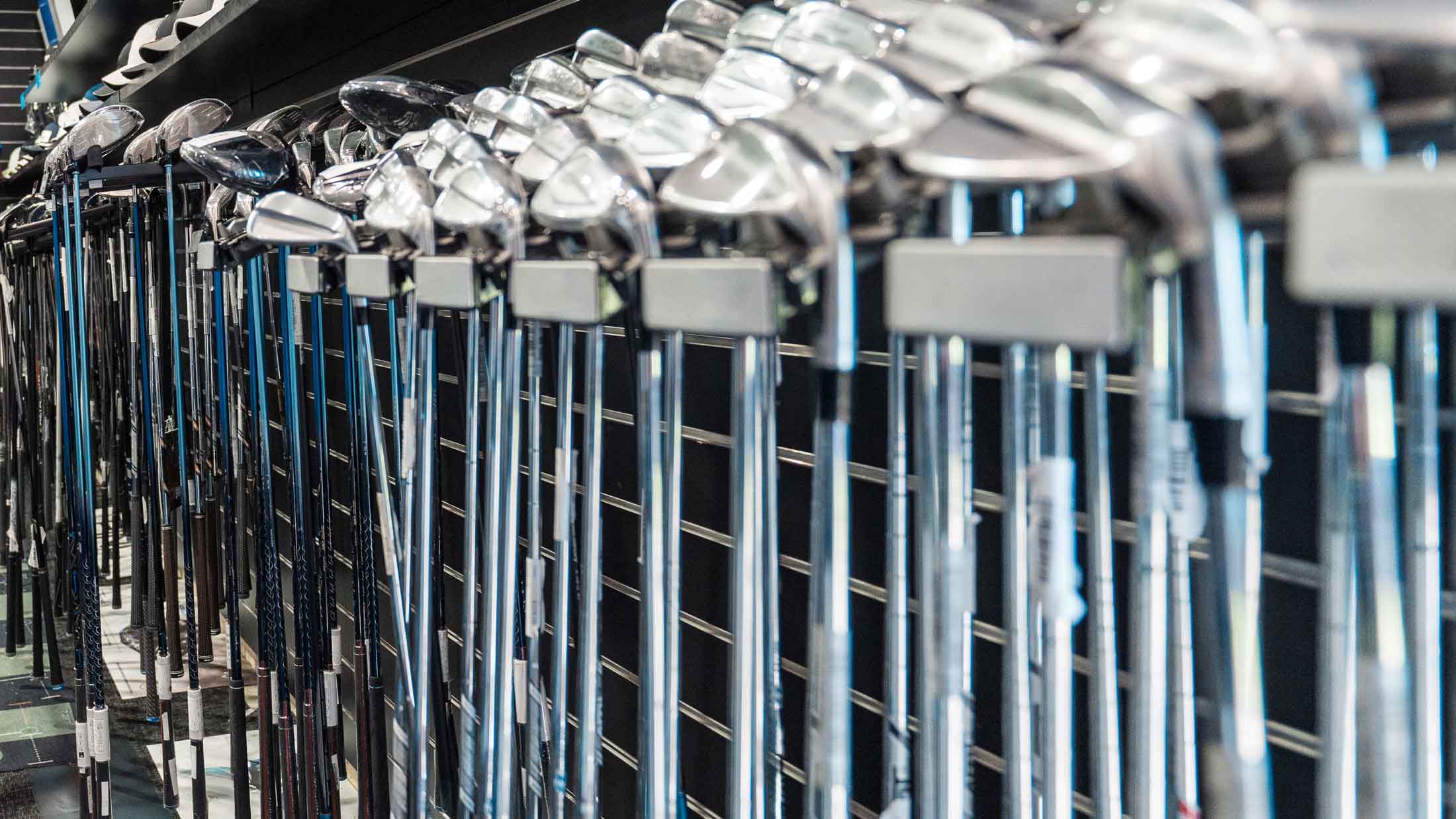 new golf clubs on rack at store