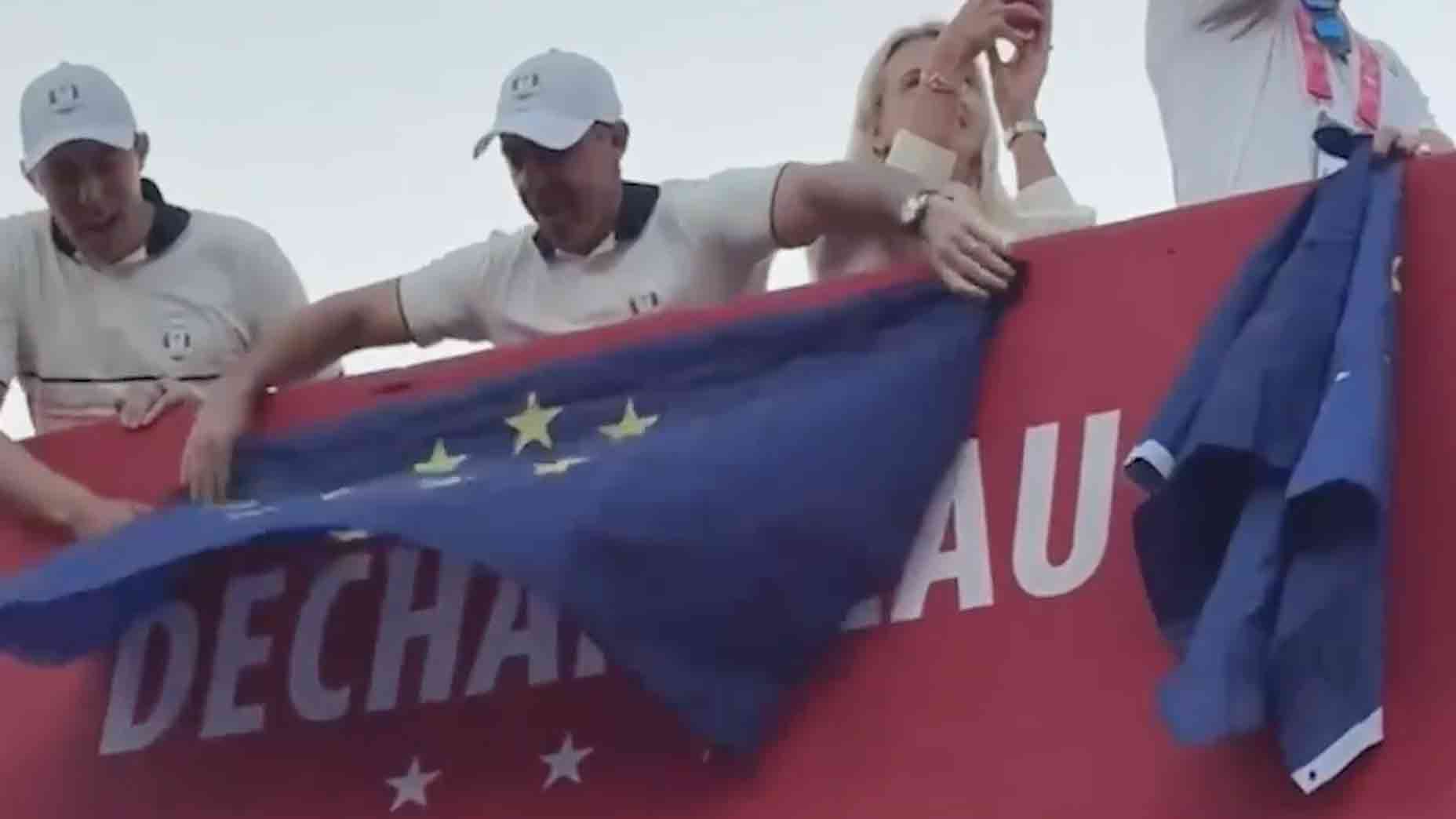 Rory McIlroy covers Bryson DeChambeau's name with a European flag.