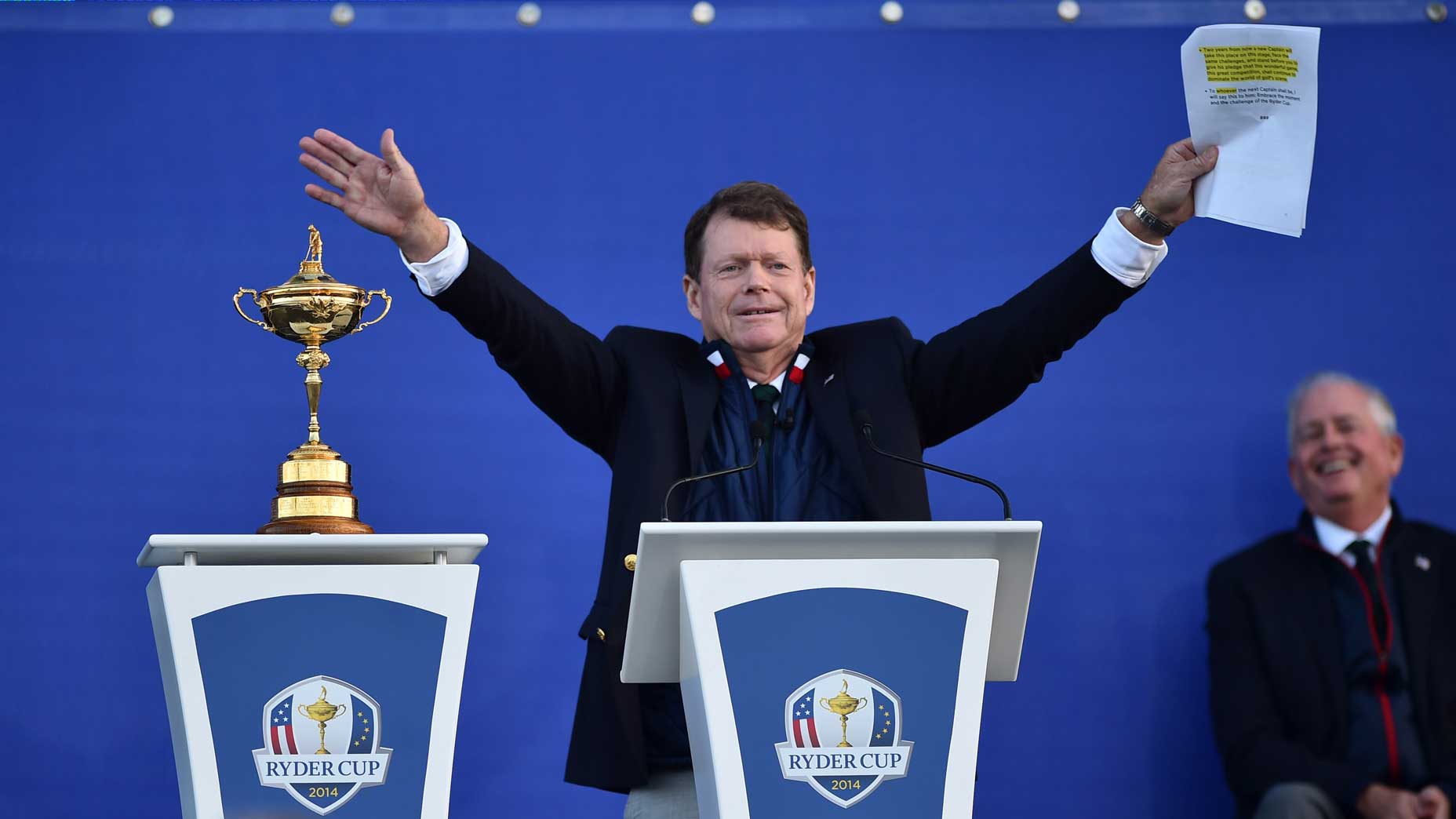U.S. Ryder Cup captain Tom Watson holds hands in air as he speaks to crowd at 2014 Ryder Cup.