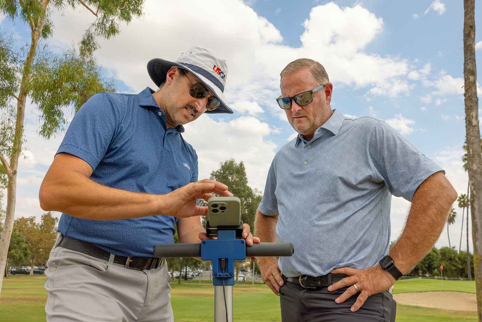 Matteo Serena (left) of the USGA shows the moisture meter to John Christianson, director of golf maintenance at Los Serranos Golf Club.